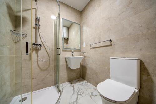 a bathroom with a shower and a toilet and a sink at The St Pauls Bay Escape Suites by 360 Estates in St Paul's Bay