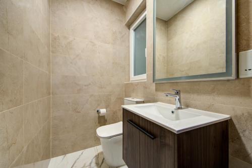 a bathroom with a toilet and a sink and a mirror at The St Pauls Bay Escape Suites by 360 Estates in St Paul's Bay
