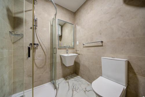 a bathroom with a shower and a toilet and a sink at The St Pauls Bay Escape Suites by 360 Estates in St Paul's Bay