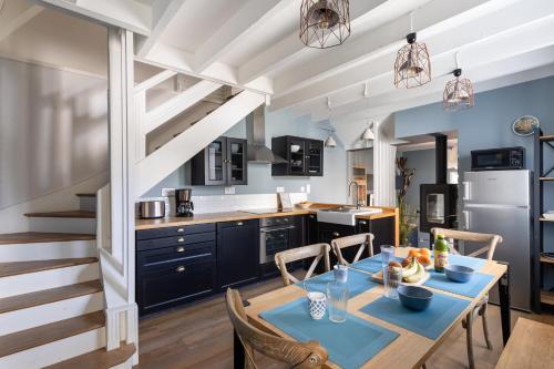 une cuisine et une salle à manger avec une table et des chaises dans l'établissement La Petite Mouette - Maison au port de Dahouët, à Pléneuf-Val-André