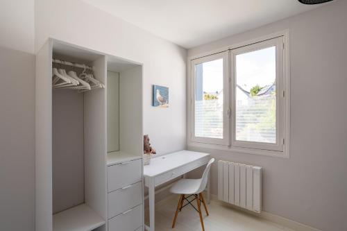 Cette chambre blanche dispose d'un bureau et d'une fenêtre. dans l'établissement La Petite Mouette - Maison au port de Dahouët, à Pléneuf-Val-André