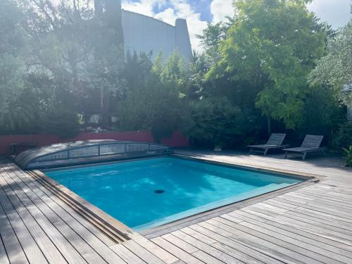 - une piscine sur une terrasse revêtue de parquet dans l'établissement La Passerelle Grande maison avec Piscine chauffée, à Rivedoux-Plage