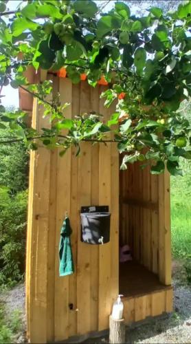 a wooden out house with a bucket and a towel at Miami Jungle Glamping in Korjuse