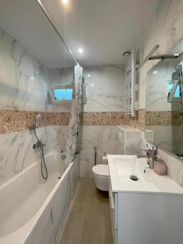 une salle de bain avec un lavabo, une baignoire et des toilettes dans l'établissement Maison familiale proche de Varaville avec jardin clos et terrasse, à Varaville