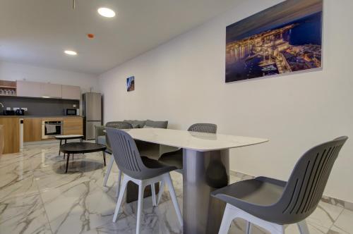 a kitchen and dining room with a table and chairs at The St Pauls Bay Escape Suites by 360 Estates in St Paul's Bay