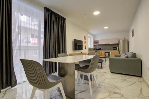 a kitchen and living room with a table and chairs at The St Pauls Bay Escape Suites by 360 Estates in St Paul's Bay