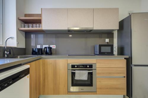 a kitchen with a stove and a microwave at The St Pauls Bay Escape Suites by 360 Estates in St Paul's Bay