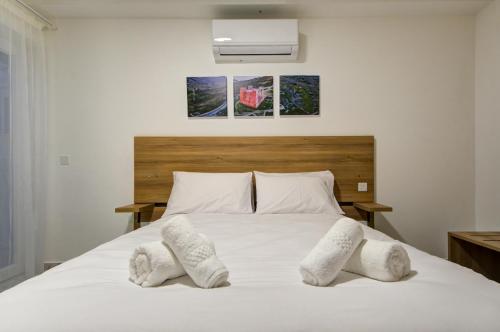 a bedroom with a white bed with two pillows at The St Pauls Bay Escape Suites by 360 Estates in St Paul's Bay