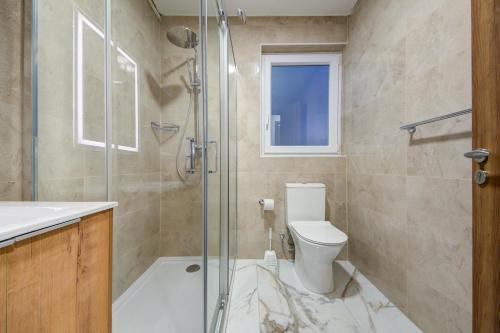 a bathroom with a toilet and a glass shower at The St Pauls Bay Escape Suites by 360 Estates in St Paul's Bay