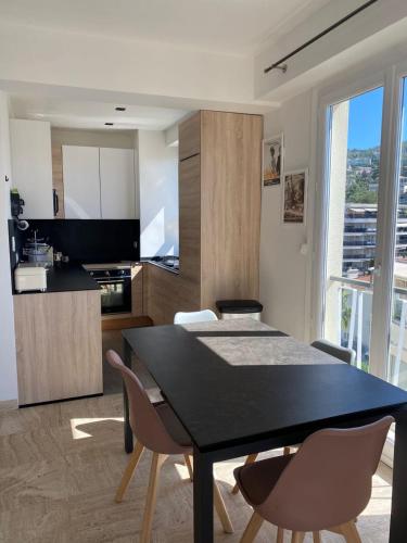 une cuisine et une salle à manger avec une table et des chaises noires dans l'établissement Yafi Velasquez, à Cannes