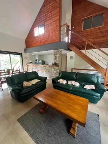 - un salon avec un canapé vert et une table en bois dans l'établissement Maison chaleureuse à Saint-Aventin avec jardin et vue montagne, à Saint-Aventin