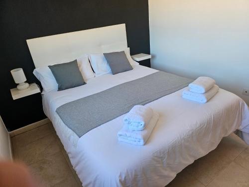 a bedroom with a large bed with towels on it at Chalet Benajarafe Beach Malaga in Benajarafe