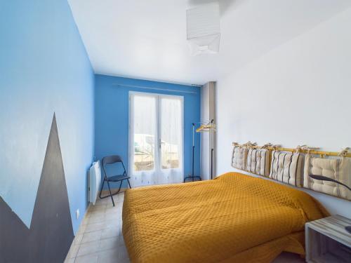 - une chambre avec un lit jaune et des murs bleus dans l'établissement Maison au calme pour 6 avec jardin, à Notre-Dame-de-Riez