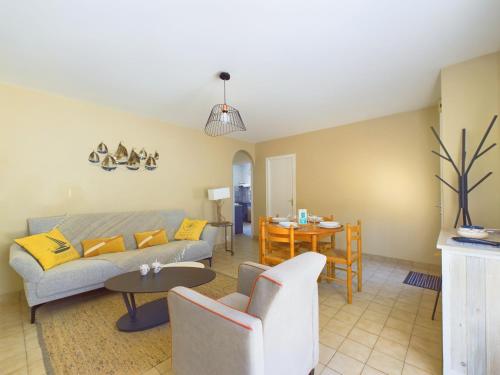 un salon avec un canapé et une table dans l'établissement Maison au calme pour 6 avec jardin, à Notre-Dame-de-Riez