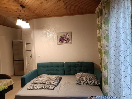 a bed in a room with a green couch at apartament blisko Energylandii in Zator