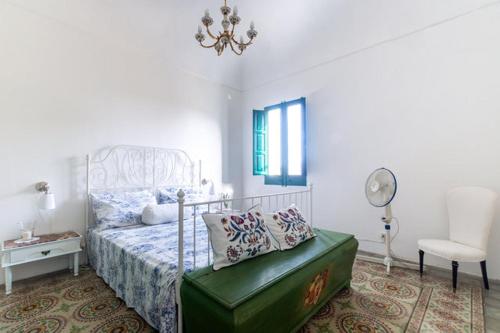 a bedroom with a bed with a green ottoman in it at Casa Betta e Elisa in Valderice