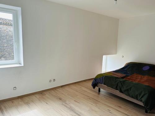 une chambre blanche avec un lit et une fenêtre dans l'établissement Nid de la lègue, à Saint-Hilaire-de-Brethmas