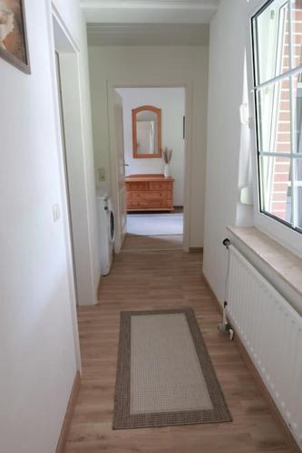 a hallway of a white room with a mirror at Ferienwohnung in idyllischer Lage in Wiesmoor