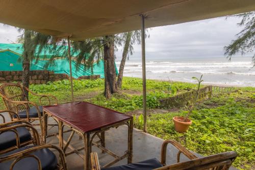 a table and chairs on a porch looking at the ocean at Seaview White beach Villa on Talpona in Magdāl