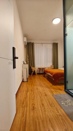 a large room with a bed and a wooden floor at Dali Vietian Guesthouse微甜 in Dali