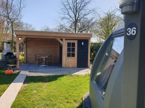 a small shed with a table in a yard at Iglo Bungalow 36 in Chaam