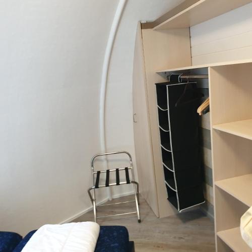 a small room with a chair and a refrigerator at Iglo Bungalow 36 in Chaam