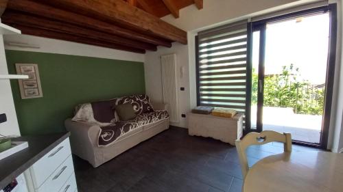 a living room with a couch and a green wall at Lake in Nature in Consiglio di Rumo