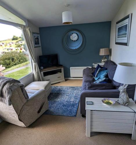 a living room with a couch and a table at Corner Cwtch in Llanstephan