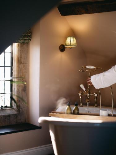 a bathroom with a sink and a lamp and a window at Boys Hall in Willesborough