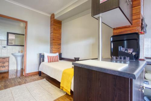 a kitchen with a sink and a bed in a room at Mar Azul 18 in Ponta Malongane