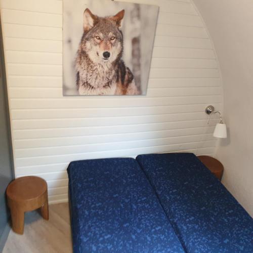 a bedroom with a wolf picture on the wall at Iglo Bungalow 36 in Chaam