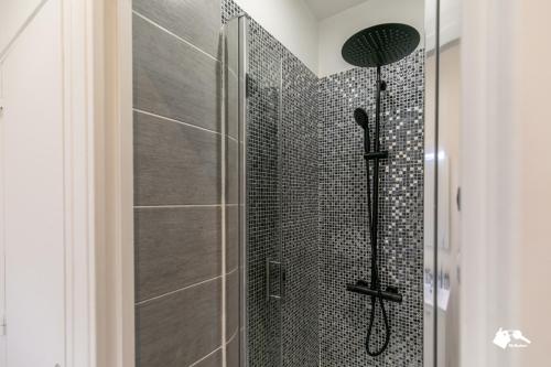 La salle de bains est pourvue d'une douche avec du carrelage noir. dans l'établissement MBA - Pétion Splendide Appart, à Paris