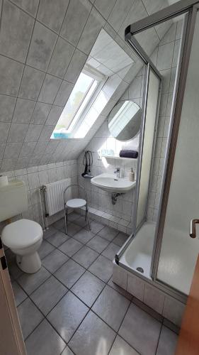 a bathroom with a toilet and a sink and a shower at Pension Sandra in Neuharlingersiel