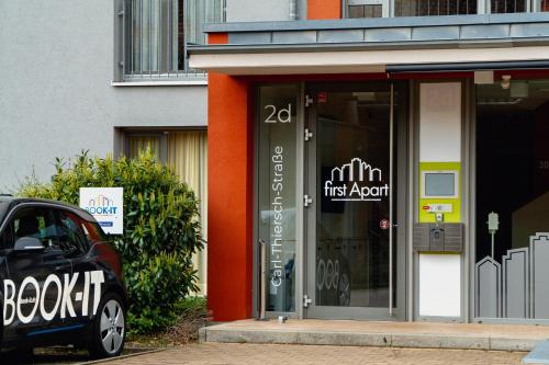 a store front with a car parked in front of it at first Apart in Erlangen