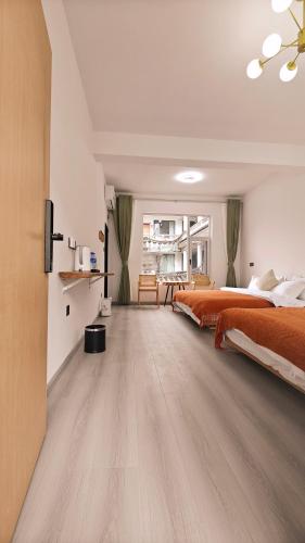 a bedroom with an orange bed and a wooden floor at Dali Vietian Guesthouse微甜 in Dali