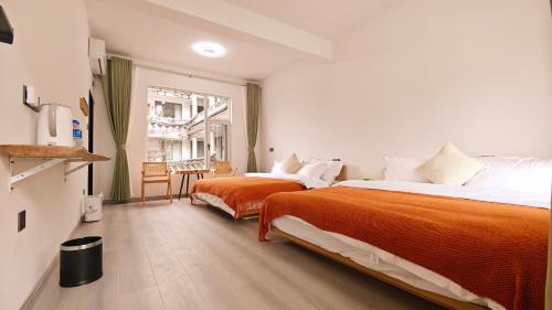 a hotel room with two beds and a table at Dali Vietian Guesthouse微甜 in Dali