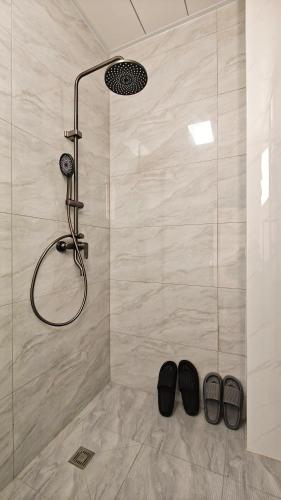 a shower with two pairs of shoes in a bathroom at Dali Vietian Guesthouse微甜 in Dali