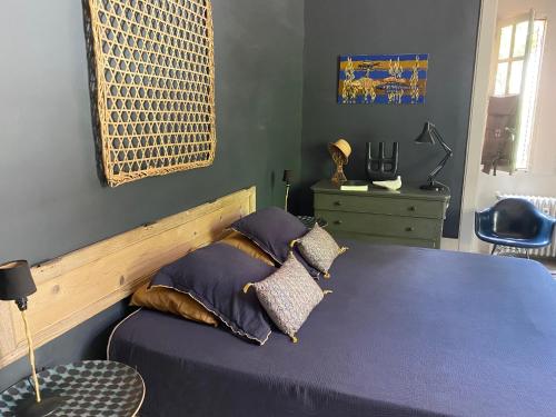 a bedroom with a bed with purple sheets and pillows at Une Nuit Au Château in Lyon
