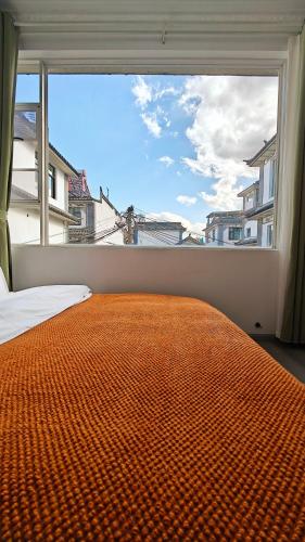 a bed in a room with a large window at Dali Vietian Guesthouse微甜 in Dali