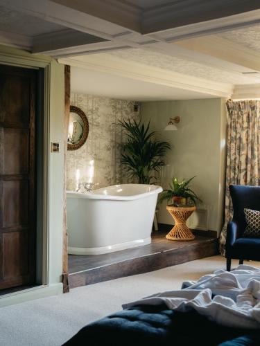 a bathroom with a tub and a plant at Boys Hall in Willesborough