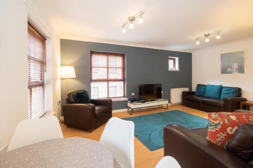 a living room with a couch and a table at Glasgow City Flats - Merchant City in Glasgow