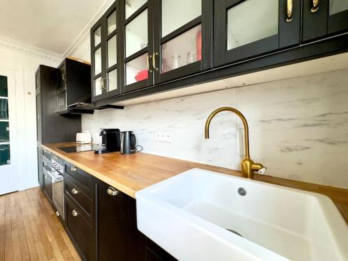 une cuisine avec un évier et un plan de travail dans l'établissement Charmant Appartement 3P - Paris 18, à Paris