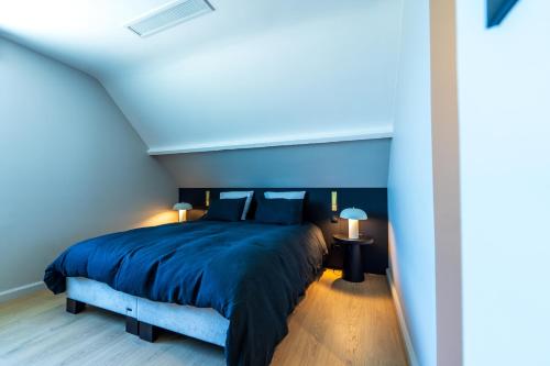 a bedroom with a bed with a blue comforter at L’Impasse in Nampty