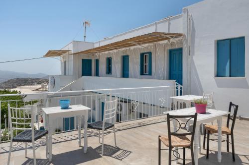 a balcony with tables and chairs and a building at Politimi Studio N8 in Amorgos