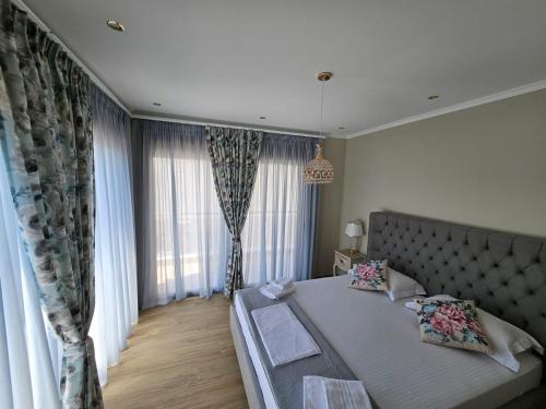 une chambre avec un lit et une grande fenêtre dans l'établissement Agora Luxury Villa II, à Loutraki