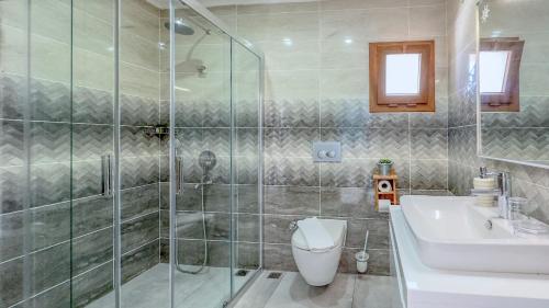 a bathroom with a shower and a toilet and a sink at Rota Otel & Restaurant in Karaburun