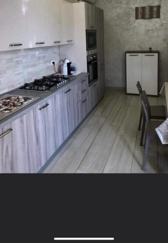 a kitchen with white cabinets and a stove and a table at Vista beb mare in Manfredonia