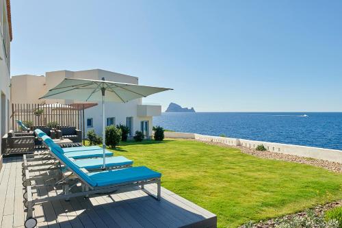 a patio with a slide and an umbrella and the ocean at 7Pines Resort Ibiza, part of Destination by Hyatt in San Jose