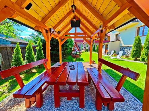 a wooden picnic table under a wooden pergola at Pokoje Gościnne Łukaszczyk in Białka Tatrzanska