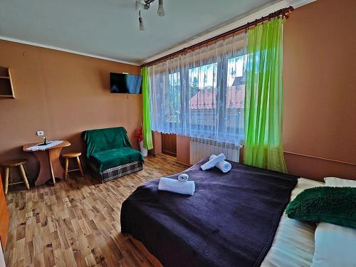 a bedroom with a bed and a window and a chair at Pokoje Gościnne Łukaszczyk in Białka Tatrzanska